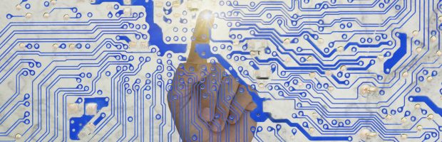 man's finger pointing a circuit board